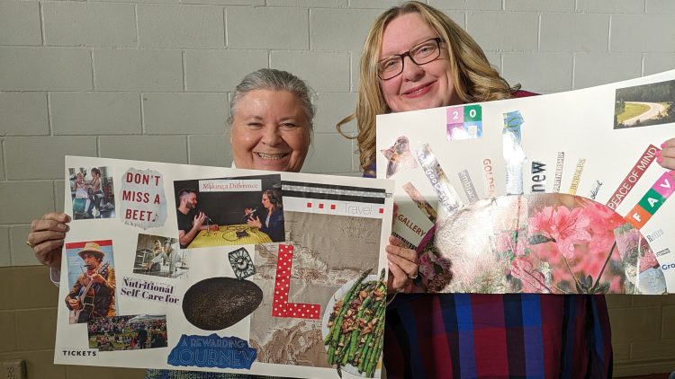 Two white women hold vision boards of collaged items up to the camera, they are both smiling softly