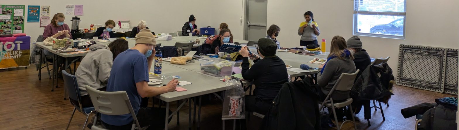 People sitting around groups of tables at Crafternoon in Ritchie Hall
