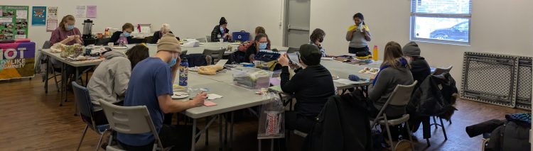 People sitting around groups of tables at Crafternoon in Ritchie Hall